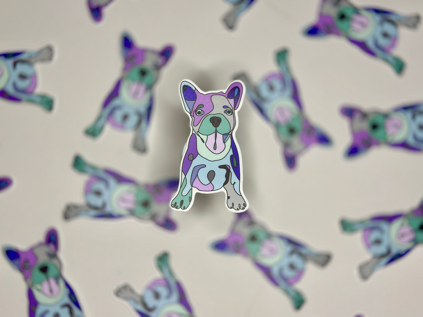 A sticker of a colorful French Bulldog with a happy expression, surrounded by the same sticker design repeated in a pattern.
