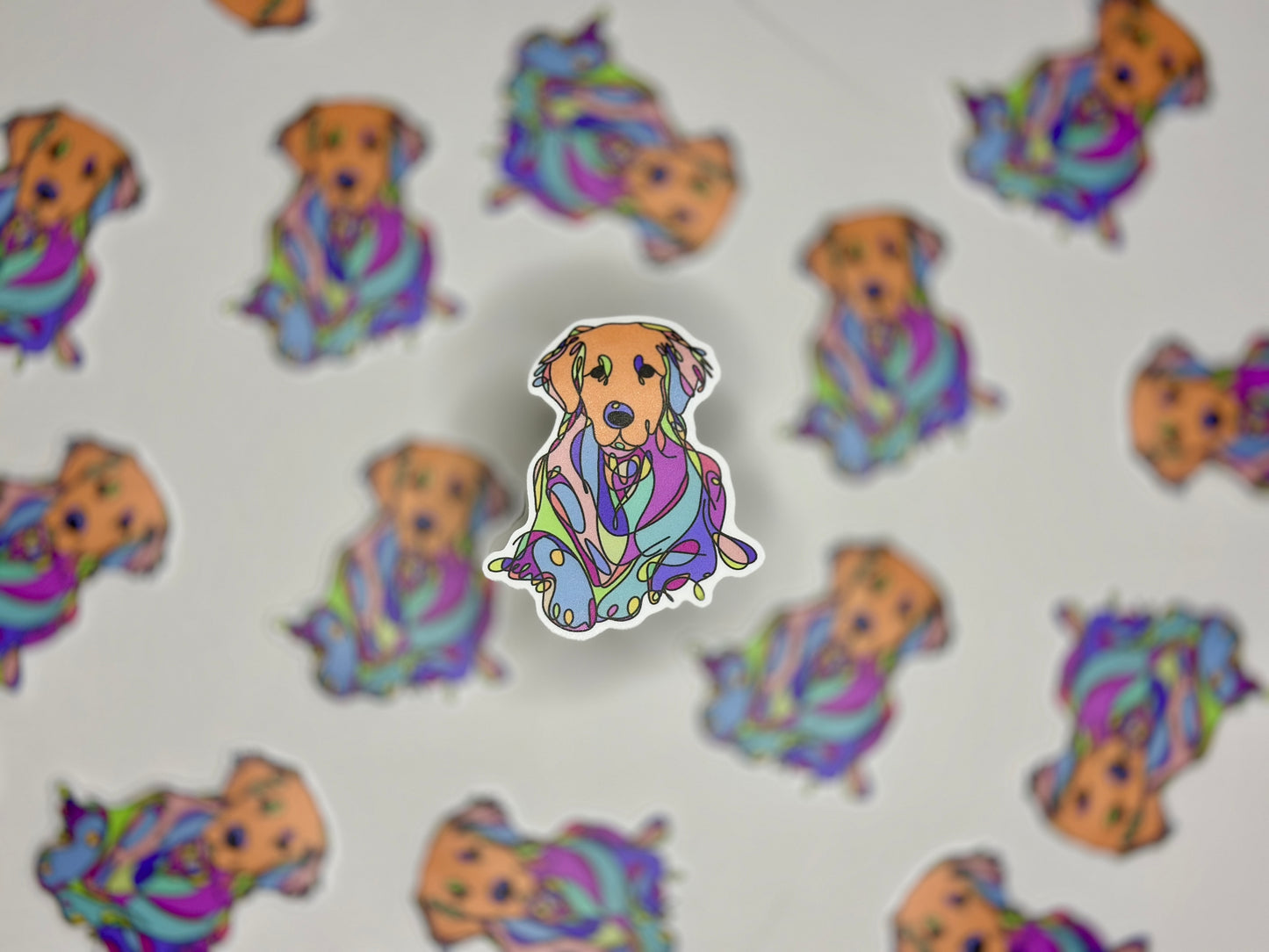 A sticker of a golden retriever with a rainbow-like pattern overlay, surrounded by the same pattern on a white background.