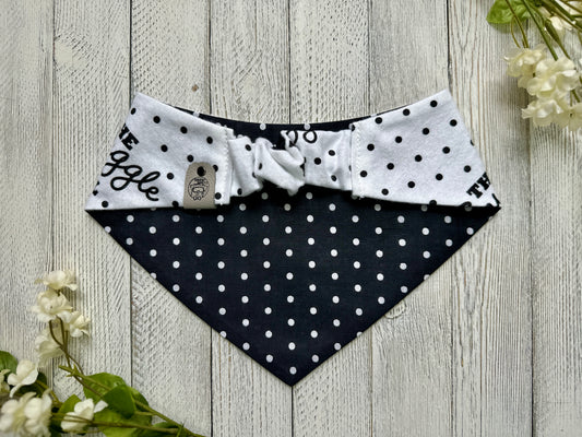 Picture of the backside of a pet bandana showing the scrunchie neckline. Displayed on a wooden surface with flowers for decoration.