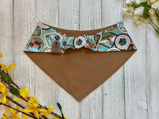 Picture of the backside of a pet bandana showing the scrunchie neckline. Displayed on a wooden surface with flowers for decoration.