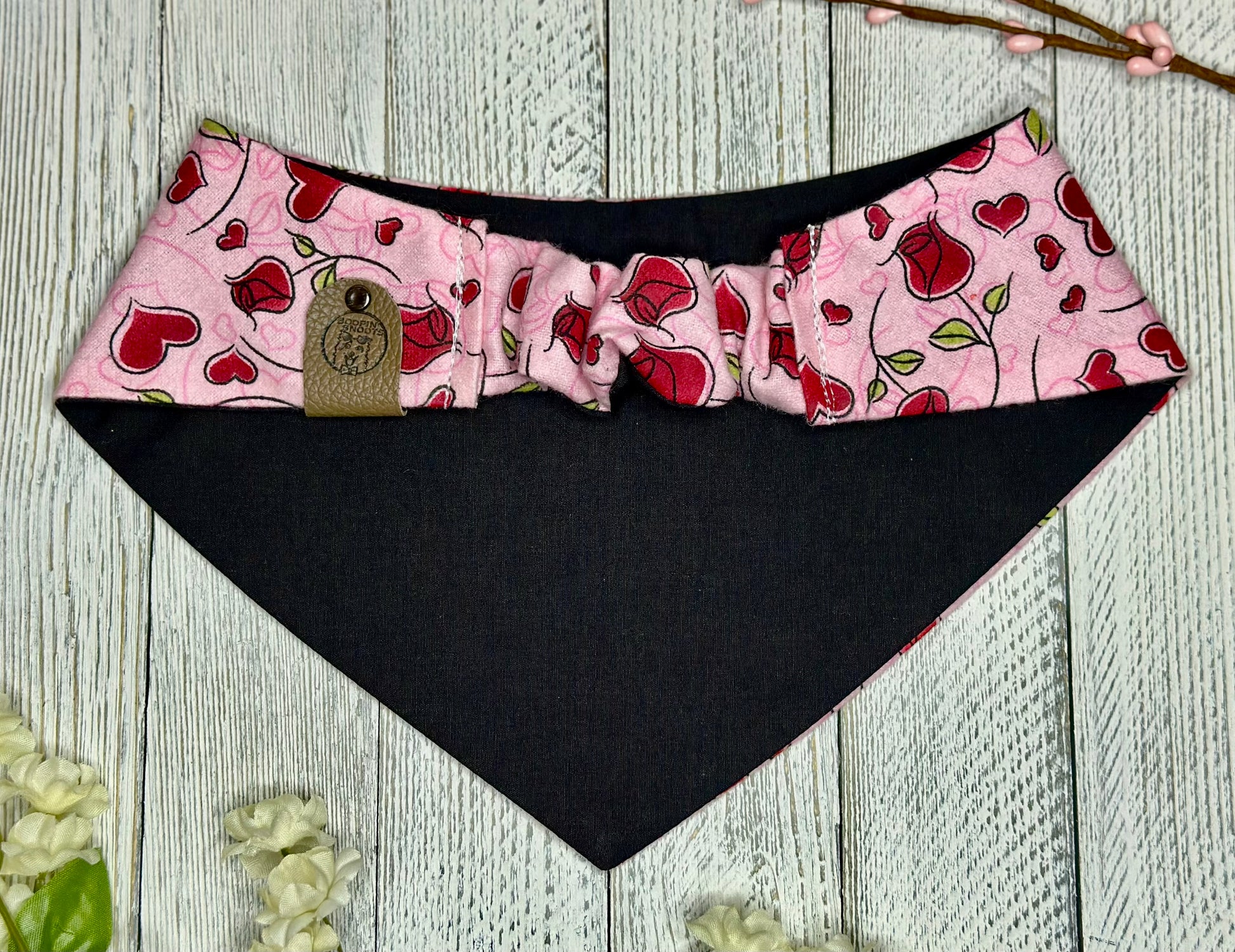 Picture of the back of a bandana showing the scrunchie design displayed on a wooden background. 