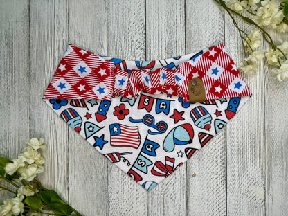 Picture of the backside of a pet bandana showing the scrunchie neckline. Displayed on a wooden surface with flowers for decoration. 