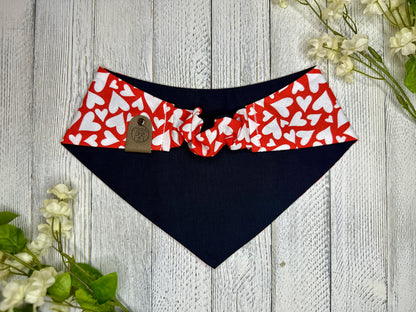 Picture of the backside of a pet bandana showing the scrunchie neckline. Displayed on a wooden surface with flowers for decoration.