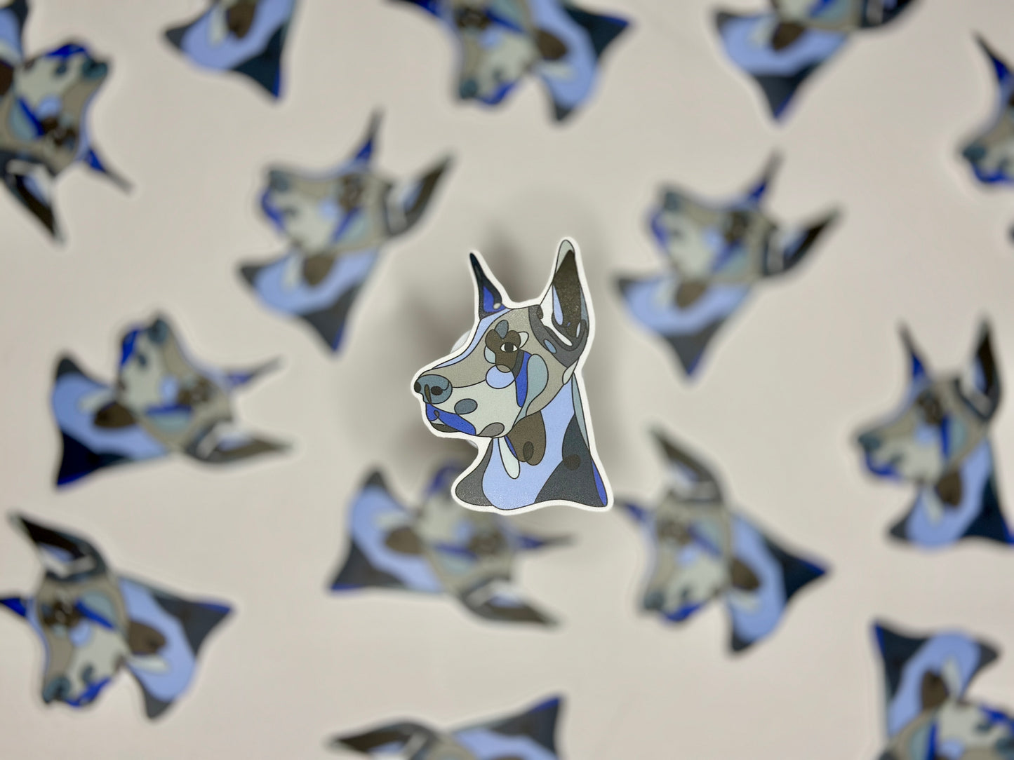 A sticker of a blue and white Doberman pinscher head in a pattern of the same image.