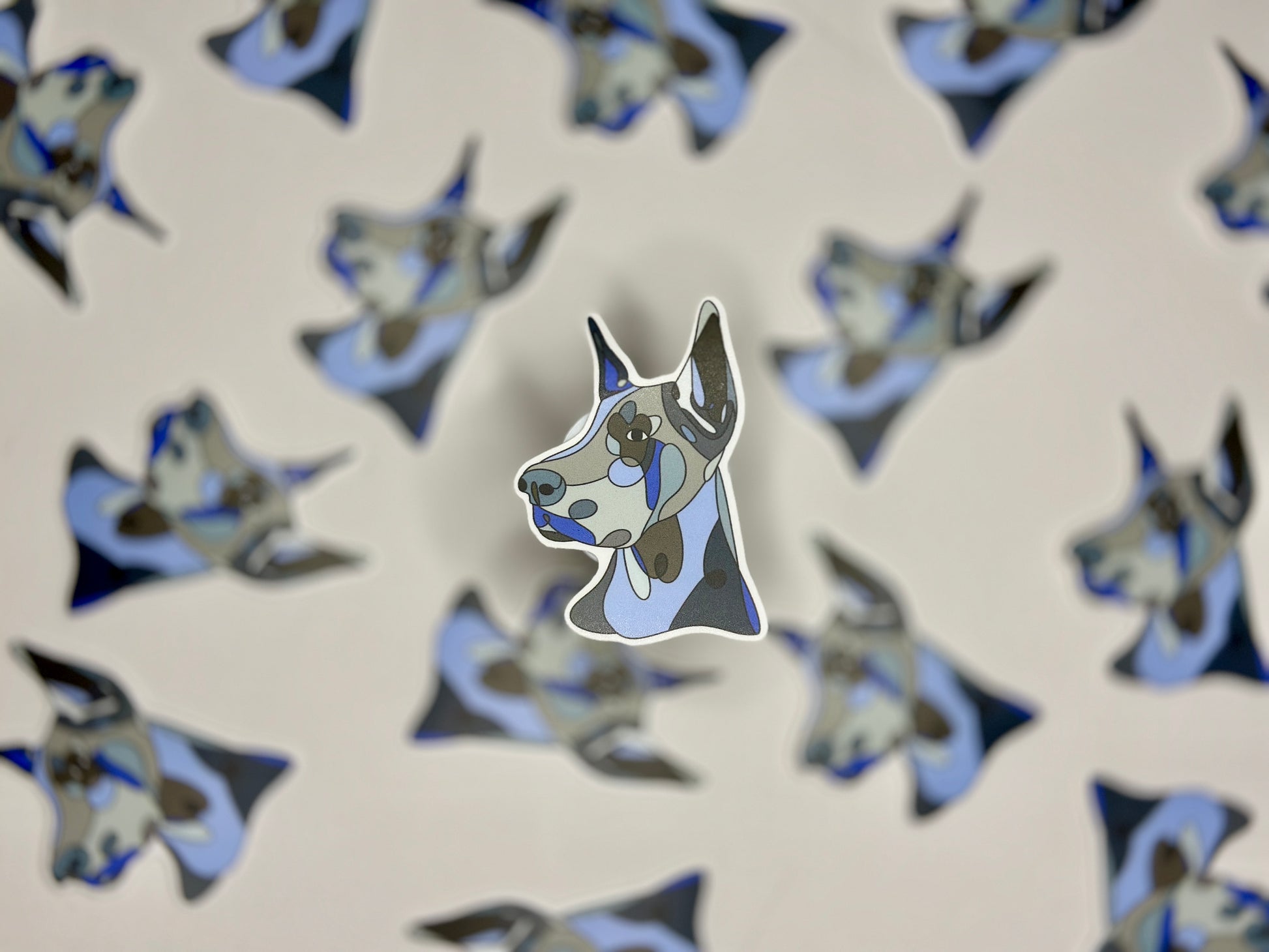 A sticker of a blue and white Doberman pinscher head in a pattern of the same image.