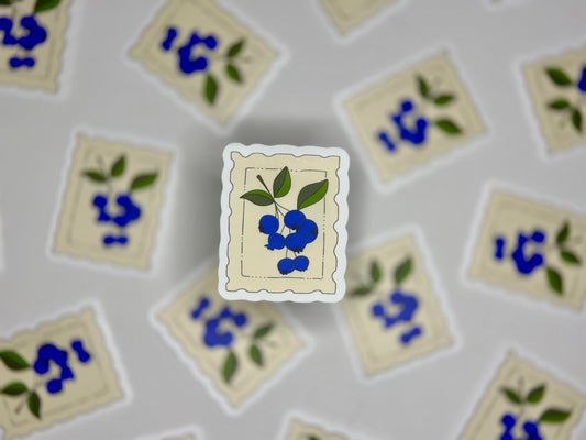Sticker showing a cream colored stamp with a blueberry drawing 