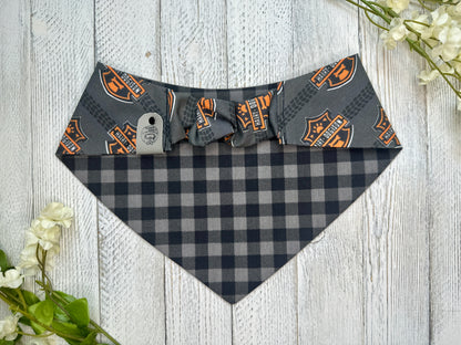 Picture of the backside of a pet bandana showing the scrunchie neckline. Displayed on a wooden surface with flowers for decoration. 