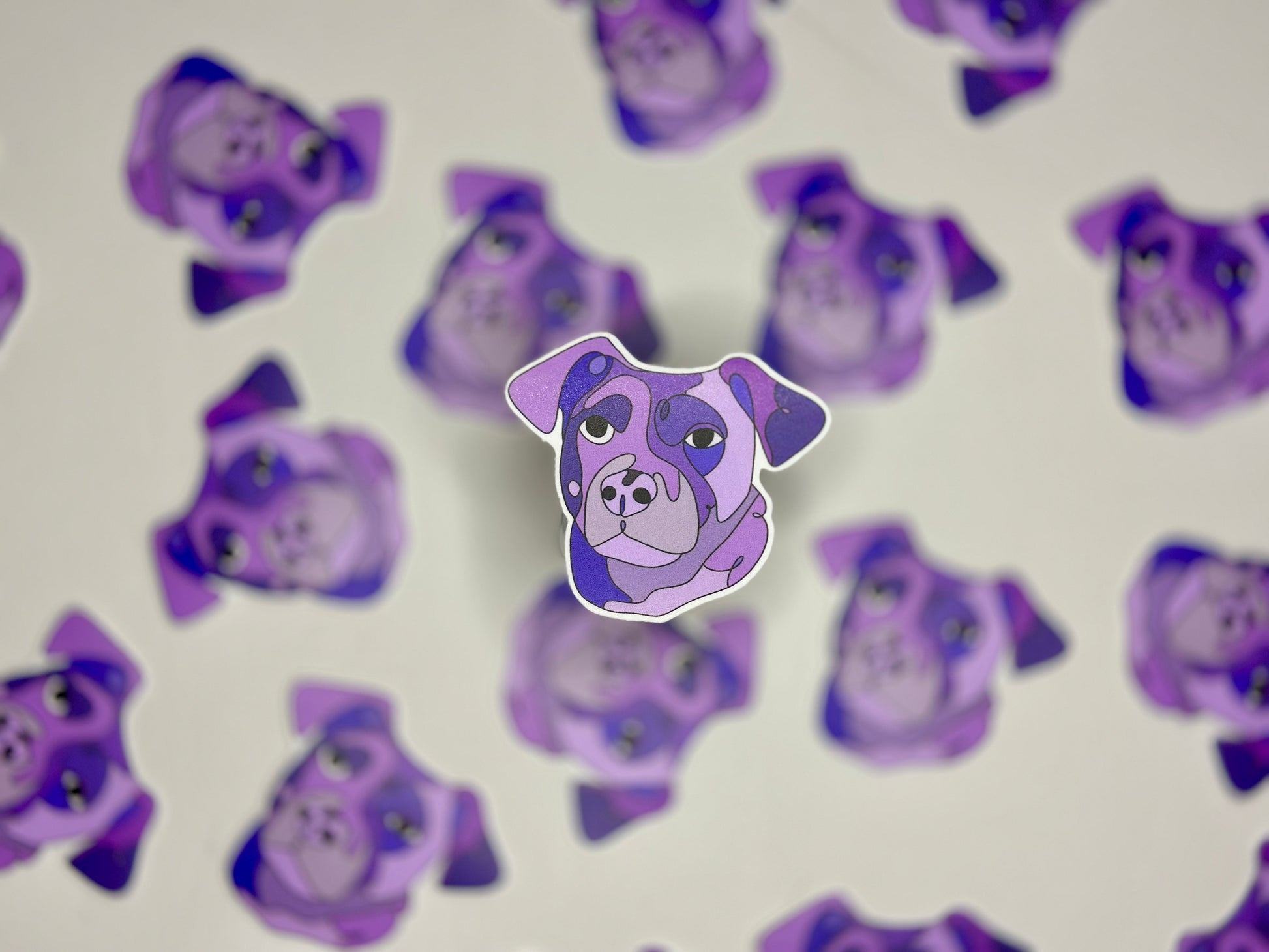 A water-resistant sticker of a Rottweiler's head in a purple color, surrounded by multiple stickers of the same design creating a pattern.