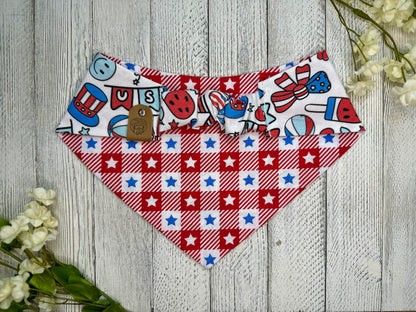 Picture of the backside of a pet bandana showing the scrunchie neckline. Displayed on a wooden surface with flowers for decoration. 